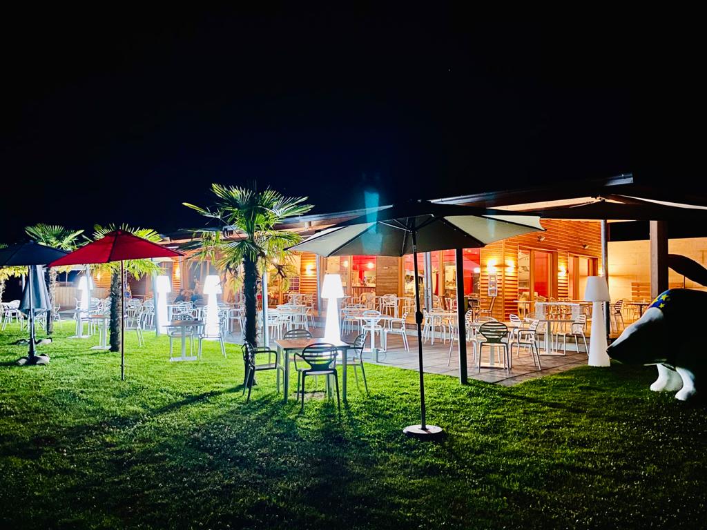 Night view of Restaurant La Sarcelle with outdoor dining area